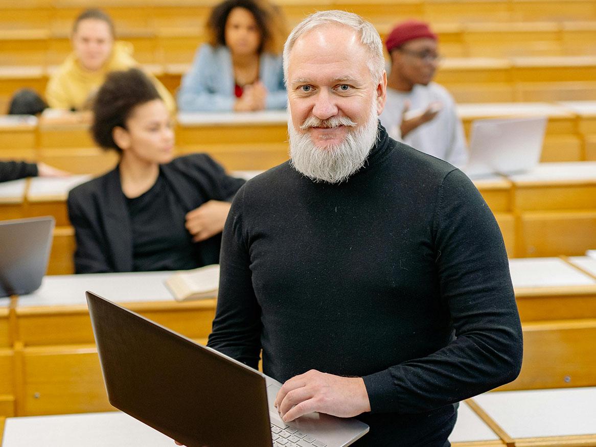 Lecturer standing in front of class in lecture theatre
